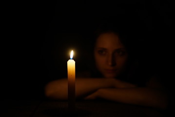 Girl with candle fire in the dark at night.
