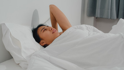 Asian indian lady sleep in room at home. Young Asian girl feeling happy relax rest lying on bed, feel comfortable and calm in bedroom at house at the morning.