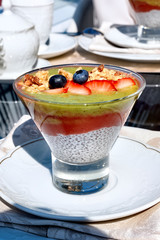 Chia pouding with fruits on a glass on a restaurant table