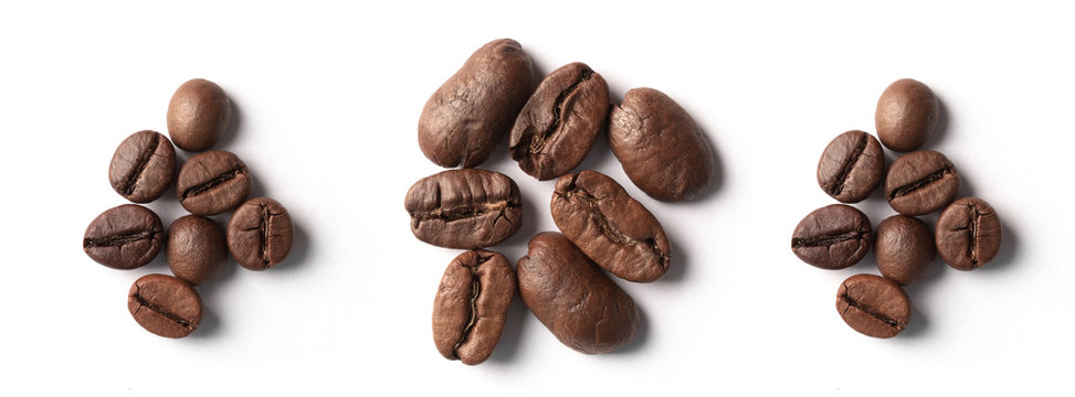 Panorama of coffee beans of different sizes on a white background.