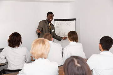 Fototapeta premium Smiling cheerful glad African American male professor giving presentation for medics in lecture hall