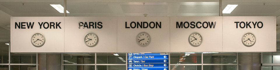 five white international clock with different time zone hanging on banner in airport station