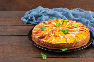 Delicious homemade peach pie on wooden background
