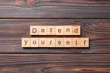 defend yourself word written on wood block. defend yourself text on cement table for your desing, concept