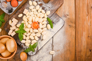 Gnocchi with potatoes. Traditional italian food from Rome, Sardinia, south of italy. Homemade gnocchi with parmesan, egg, cornmeal (semolina). On a wooden table. High quality photo. Copy space 