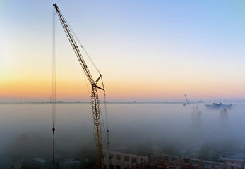 Fototapeta premium Crane silhouette and Koblevo skyline in the morning mist, Ukraine