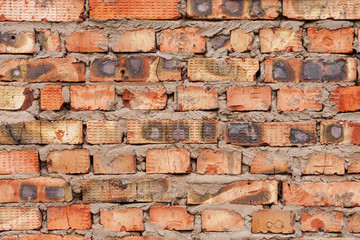 The wall with a masonry of red baked bricks is fastened with cement mortar and forms the base of the house.