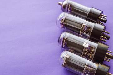Four vacuum tubes on a blue background.