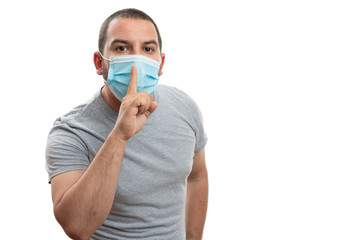 Adult man making be quiet gesture wearing mask with copyspace