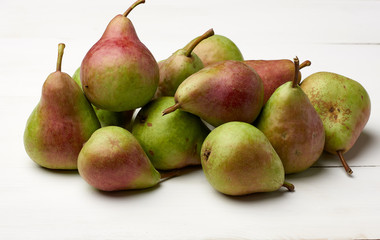 bunch of ripe green pears on a white wooden table
