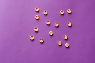 Bingo game plastic chips on  lilac background.