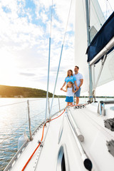Fototapeta premium Family Sailing Relaxing During Yacht Ride Standing On Deck, Vertical