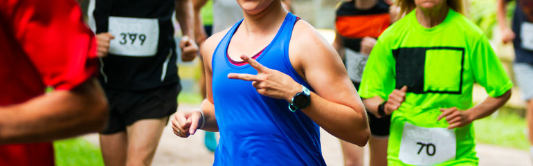 Runner giving peace sign during a trail 10K race