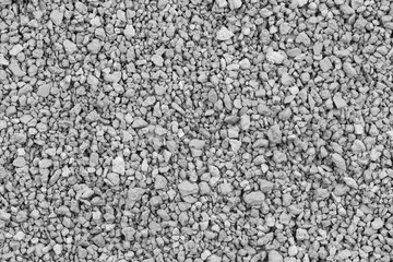 Gray small rocks ground texture. black small road stone background. gravel pebbles stone seamless texture. dark background of crushed granite gravel, close up. clumping clay