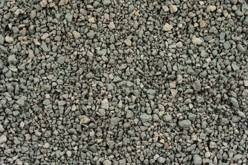 Gray small rocks ground texture. black small road stone background. gravel pebbles stone seamless texture. dark background of crushed granite gravel, close up. clumping clay