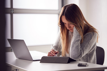 Businesswoman Working From Home Drawing On Digital Tablet Using Stylus Pen