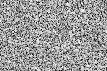 Gray small rocks ground texture. black small road stone background. gravel pebbles stone seamless texture. dark background of crushed granite gravel, close up. clumping clay