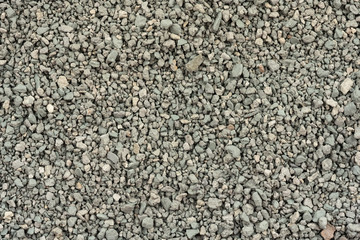 Gray small rocks ground texture. black small road stone background. gravel pebbles stone seamless texture. dark background of crushed granite gravel, close up. clumping clay