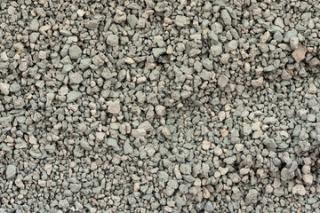 Gray small rocks ground texture. black small road stone background. gravel pebbles stone seamless texture. dark background of crushed granite gravel, close up. clumping clay