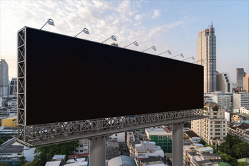 Blank black road billboard with Bangkok cityscape background at sunset. Street advertising poster, mock up, 3D rendering. Side view. The concept of marketing communication to promote or sell idea.