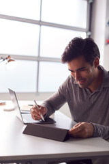 Businessman Working From Home Drawing On Digital Tablet Using Stylus Pen