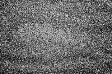 Gray small rocks ground texture. black small road stone background. gravel pebbles stone seamless texture. dark background of crushed granite gravel, close up. clumping clay