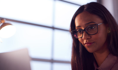 Businesswoman Working On Laptop At Desk In Modern Office