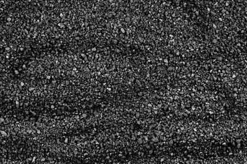 Gray small rocks ground texture. black small road stone background. gravel pebbles stone seamless texture. dark background of crushed granite gravel, close up. clumping clay