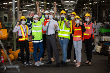 Group of Engineer manager and Factory Workers Team standing against production line.