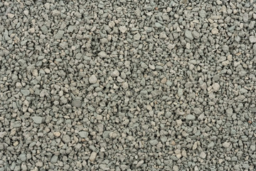 Gray small rocks ground texture. black small road stone background. gravel pebbles stone seamless texture. dark background of crushed granite gravel, close up. clumping clay