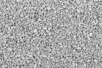 Gray small rocks ground texture. black small road stone background. gravel pebbles stone seamless texture. dark background of crushed granite gravel, close up. clumping clay