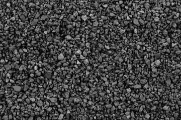 Gray small rocks ground texture. black small road stone background. gravel pebbles stone seamless texture. dark background of crushed granite gravel, close up. clumping clay
