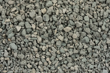 Gray small rocks ground texture. black small road stone background. gravel pebbles stone seamless texture. dark background of crushed granite gravel, close up. clumping clay