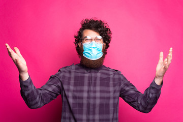 Portrait of man wearing mask and making welcome gesture.