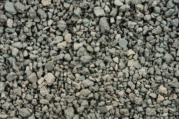 Gray small rocks ground texture. black small road stone background. gravel pebbles stone seamless texture. dark background of crushed granite gravel, close up. clumping clay