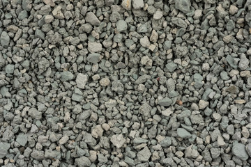 Gray small rocks ground texture. black small road stone background. gravel pebbles stone seamless texture. dark background of crushed granite gravel, close up. clumping clay