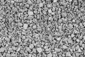Gray small rocks ground texture. black small road stone background. gravel pebbles stone seamless texture. dark background of crushed granite gravel, close up. clumping clay