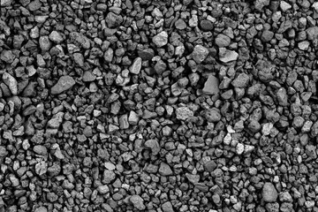Gray small rocks ground texture. black small road stone background. gravel pebbles stone seamless texture. dark background of crushed granite gravel, close up. clumping clay