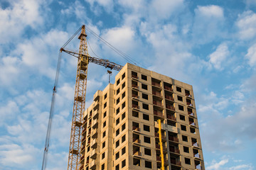 against the blue sky with clouds construction of a multi-storey building