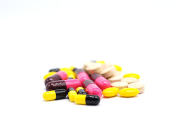 Close up of pills and pill capsules on white blurred background.