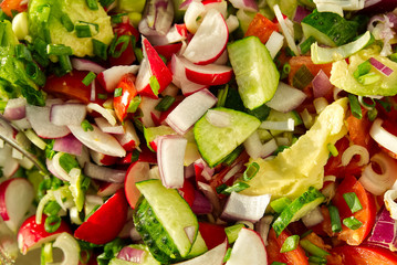 summer vegetarian vegetable salad. home cooking Vitamin salad of tomato, cucumber, onion, avocado and radish. top view of the vitamin salad.