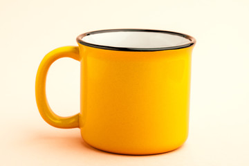 An empty iron mug on a yellow background