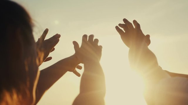 happy family people group pull hands to the sun teamwork. silhouette people party dancing recreation holiday. people at a music concert pull their lifestyle hands up. religion concept sunlight