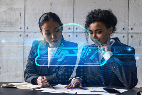 Two businesswomen work together in modern office on new project. Double exposure. Concept of success. Cloud hologram.