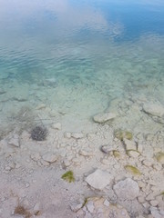 Fototapeta na wymiar Azure clear sea water. Background of transparent blue sea water top view. Crystal clear water, through the water you can see the bottom. soft focus