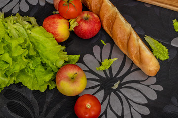 Healthy food concept. Apples, salad and french bread on black table background, top view, copy space, soft focus