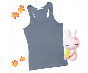 Gray tank top with soft toy and fall leaves on white background