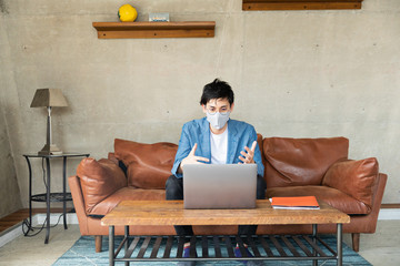 man with protective face mask working at home