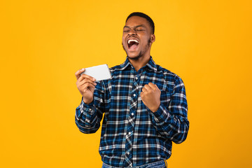 Joyful Black Man Holding Smartphone Shouting Shaking Fists In Studio