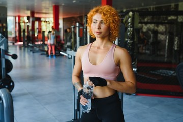 Fitness Girl With Strong Body Having Break Between Cardio Workout. Sporty Woman In Fashion Sportswear Resting After Intense Exercising. Fit Female With Muscular Body Looking Tired.
